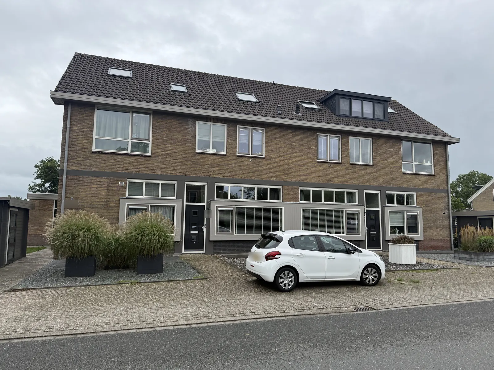 Appartementen in de voormalige brandweerkazerne in Spanbroek, met voordeuren, grijze raamkaders en dakramen