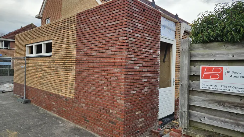 Hoek van de garage in Spanbroek tijdens de bouw, metselwerk in lichte en donkerrode baksteen