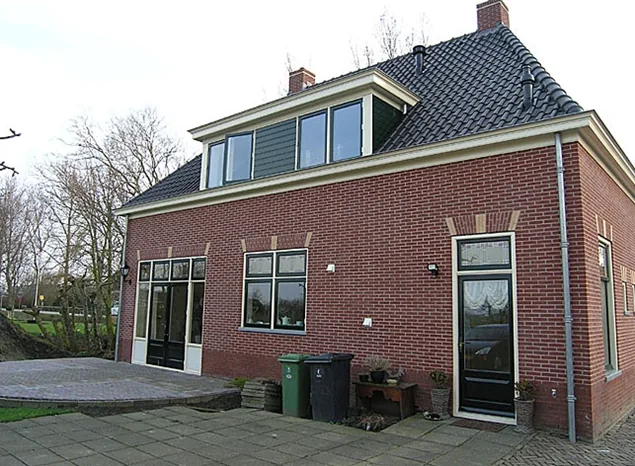 Achtergevel van de notariswoning in Spanbroek met dakkapel, terrasdeuren en terras