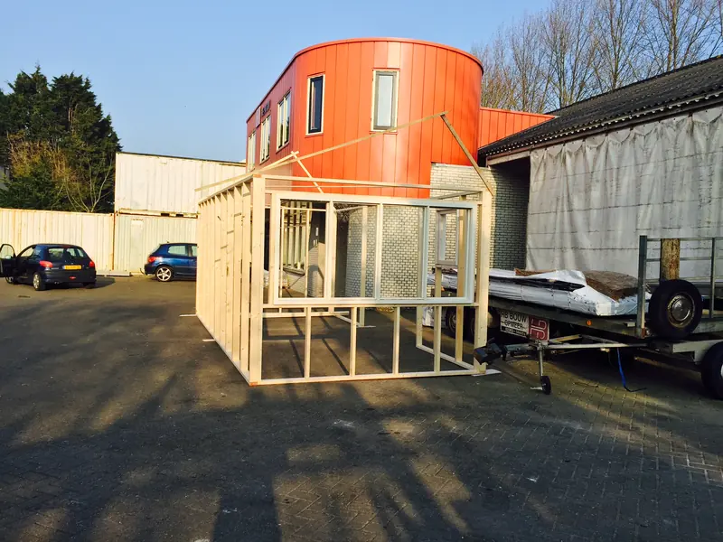 Houten skelet van de schuur met witte raamkozijnen, voor de werkplaats van HB Bouw