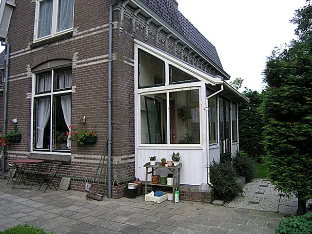 Witte serre aan de zijgevel met terras, stoomgemaal in Medemblik