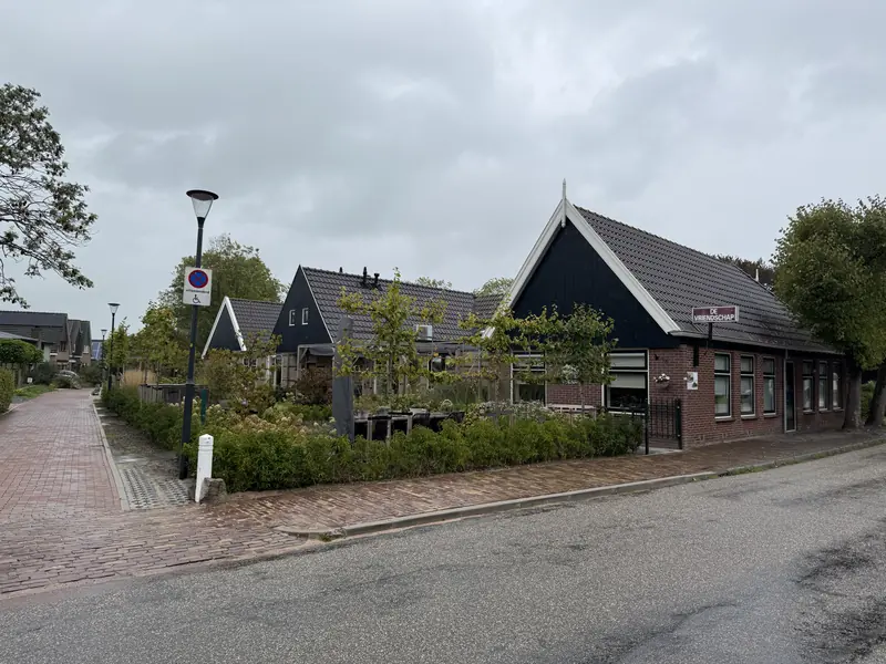Zijde met zwarte houten topgevels en naambord De Vriendschap op het voormalige café