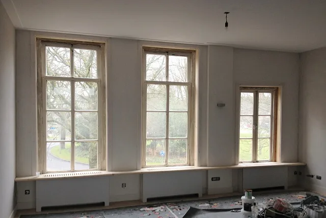 Dezelfde kamer in Alkmaar in de oude staat, tijdens de verbouwing: kozijnen kaal, vloer afgedekt
