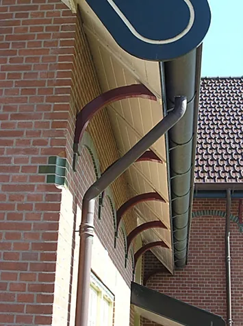 Gootlijst op gebogen consoles met regenpijp langs rode baksteen, villa in Spanbroek
