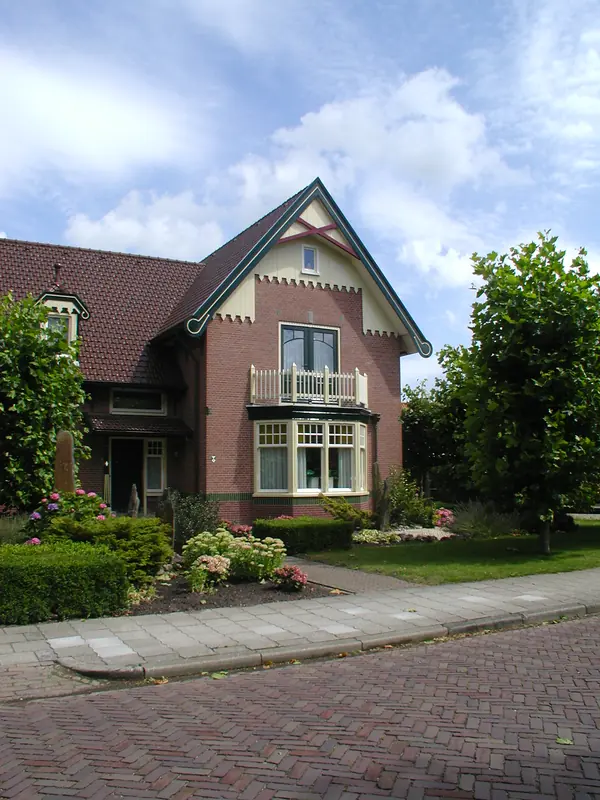 Kopgevel met erker, balkon met witte balustrade en groene windveren, villa in Spanbroek