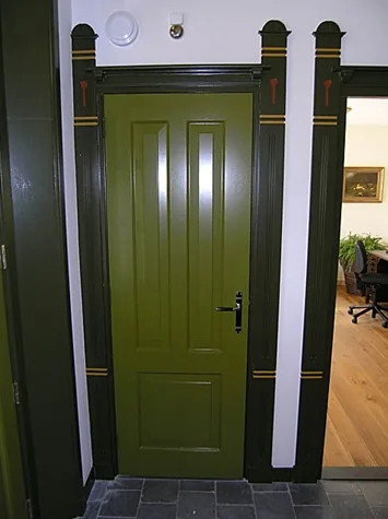 Groene paneeldeur in een donkere omlijsting met beschilderde pilasters en natuurstenen vloer, Spanbroek