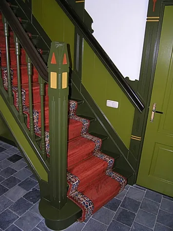 Trappaal met beschilderde punten en rode loper op een grijze natuurstenen vloer, villa in Spanbroek