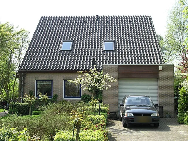 Voorgevel van het woonhuis in Langedijk met pannendak, twee dakramen en garage